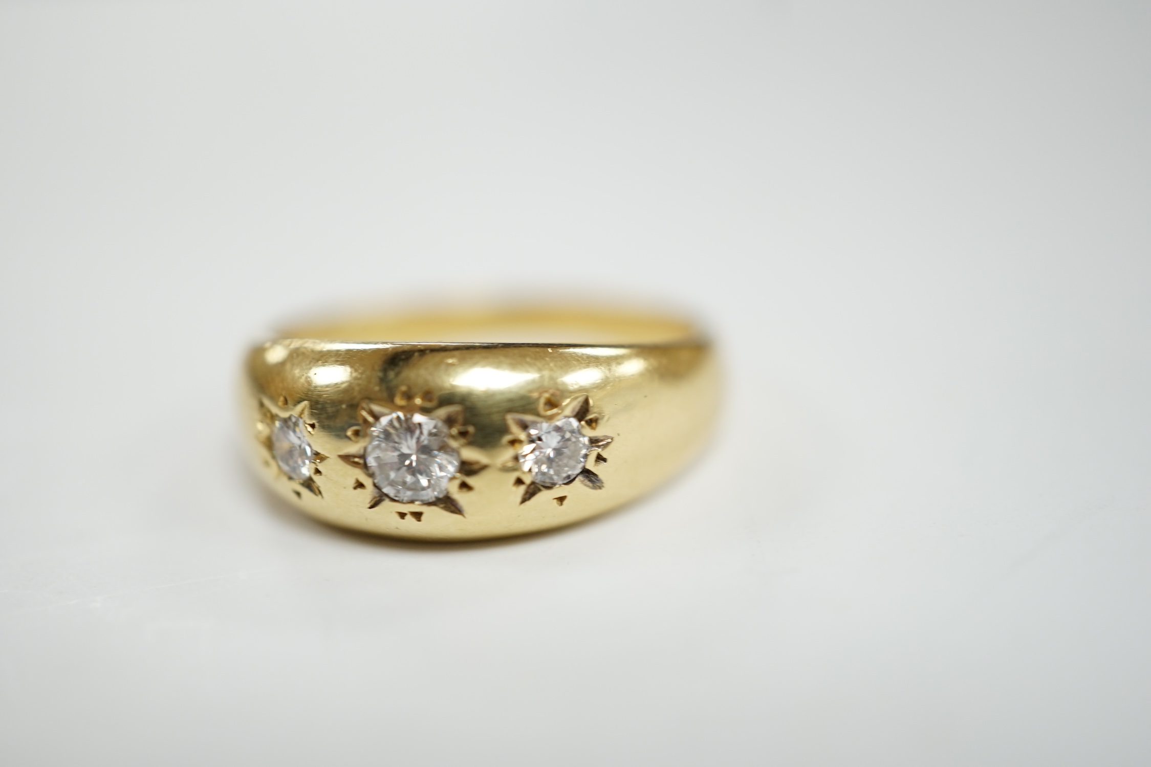 A modern 18ct gold and gypsy set three stone diamond ring, size S, gross weight 7.9 grams.